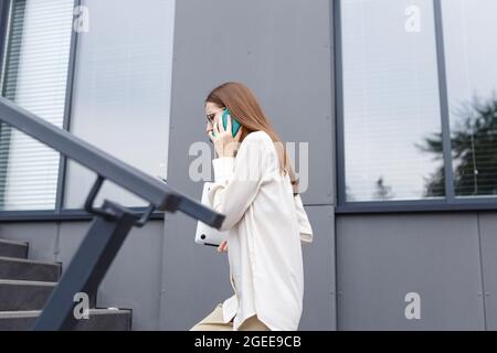 young stylish white woman talking on a smartphone Stock Photo