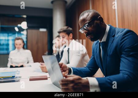 African american black man businessman sitting at table working laptop on office team people background Stock Photo