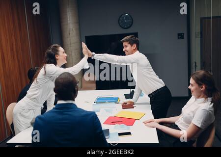 Businessman and businesswoman team at office meeting. Business people group conference discussion give high five deal and success Stock Photo