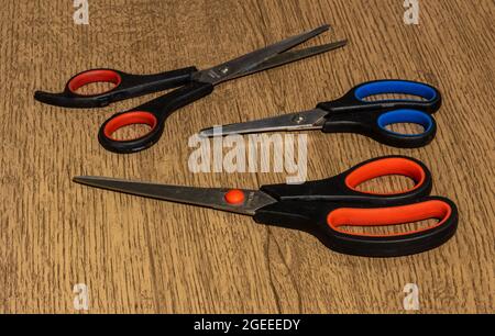 Three scissors on a wood surface Stock Photo