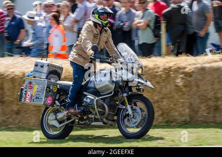 Charley Boorman riding BMW R1150GS motorcycle up the hill climb track at the Goodwood Festival of Speed motor racing event 2014 Stock Photo