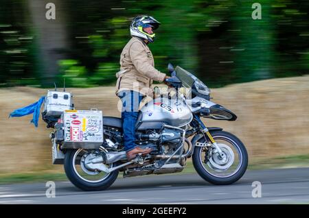 Charley Boorman riding BMW R1150GS motorcycle up the hill climb track at the Goodwood Festival of Speed motor racing event 2014 Stock Photo