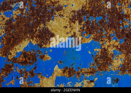 flat texture of rusted steel sheet with two peeled off layers of paint - yellow and blue Stock Photo
