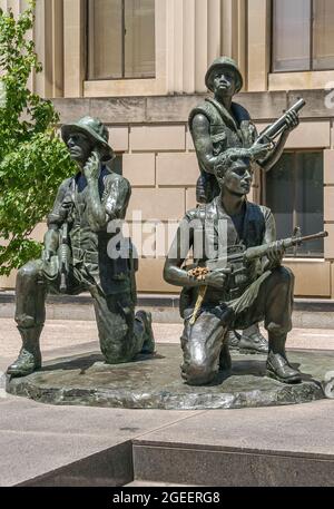 Nashville, TN, USA - May 19, 2007: Downtown. Vietnam war memorial statue showing 3 soldiers in bronze in front of War Memorial building. Some green fo Stock Photo