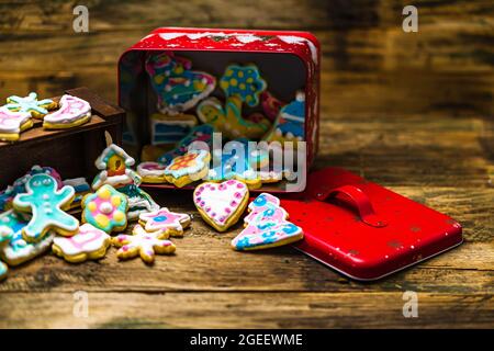 Closeup shot of tasty, homemade, and colorful Christmas cookies falling out from the metal box Stock Photo