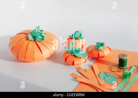 Several paper pumpkins, hand made from strips of colored paper. DIY concept for helloween crafts Stock Photo