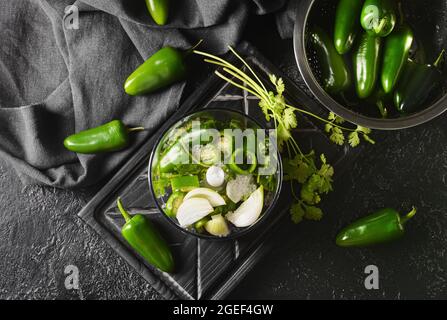 Blender with ingredients for Tomatillo Salsa Verde sauce on dark background Stock Photo