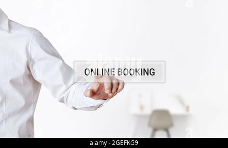 Businessman pressing the word online booking on a virtual search display screen. Travel and tourism business technology concept. Stock Photo