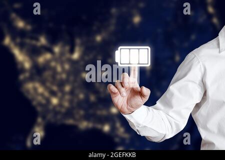 Businessman pressing full battery charge icon on a virtual display screen. Universal battery charge concept. Stock Photo