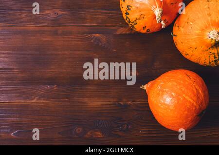 Top view of Hokkaido pumpkins on dark brown wooden table with copy space Stock Photo