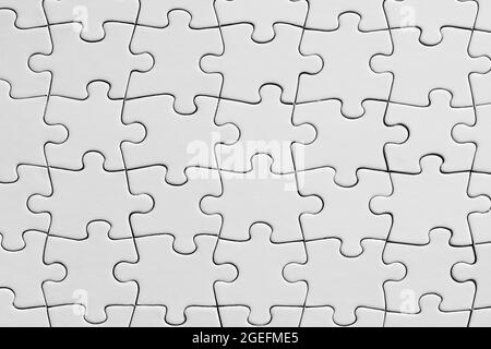 Empty white jigsaw puzzle background. Overhead view with copy space. Stock Photo