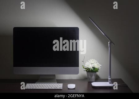 workplace with computer and table lamp in the night time Stock Photo