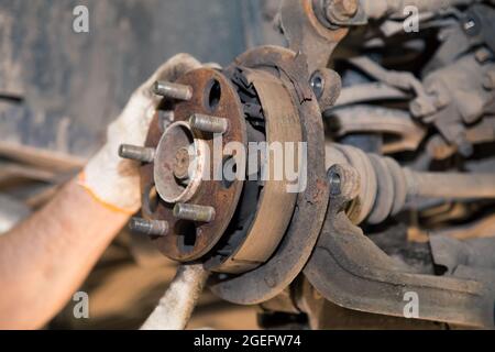 The man's hands remove the worn and rusted brake pads from the rear wheel.  In the garage, a person changes the failed parts on the vehicle. Small  business concept, car repair and maintenance service Stock Photo - Alamy