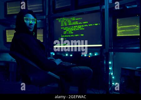Cyber hacker breaks into databases to obtain information using a computer. Cybercrime and data security concept. Stock Photo