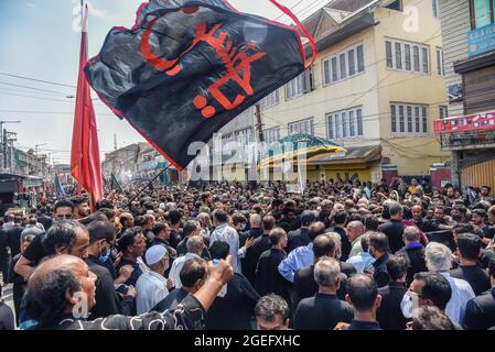 A Kashmiri Shia Muslim man waves a religious flag inside an imam badah ...