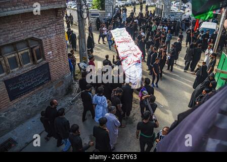 Kashmiri Shia Muslims carry a religious flag during the Ashura ...