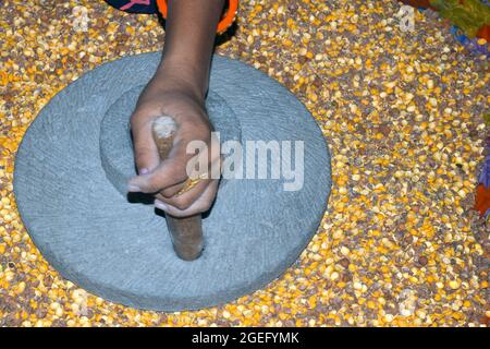 A village woman's hand, grinds gram in an old hand operated flour mill. Stock Photo