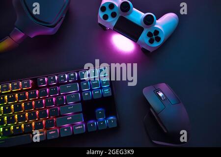Top down view of various gaming accessories laying on table. Colorful illuminated devices. Professional computer game playing, esport business and onl Stock Photo