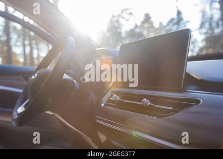 interior of modern luxury car in sunshine. monitor, airduct and steering wheel on premium car, side view, sunlight Stock Photo
