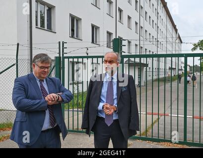 Doberlug Kirchhain, Germany. 20th Aug, 2021. Olaf Jansen (l), head of Brandenburg's Central Foreigners Authority, and Markus Grünewald, State Secretary in Brandenburg's Ministry of the Interior, wait for the start of a press conference in front of the grounds of the DRK Refugee Aid at the initial reception facility. Early this morning, at around 4:30 a.m., two buses from the airport in Frankfurt am Main arrived here at Brandenburg's Central Foreigners Authority with almost 59 local staff from Afghanistan. Credit: Patrick Pleul/dpa-Zentralbild/dpa/Alamy Live News