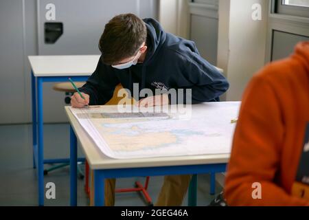 Technical college “Lycee Pierre Loti” in Paimpol (Brittany, north western France): student in a classroom working on a nautical chart. Maritime colleg Stock Photo