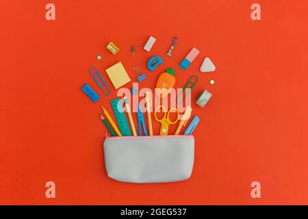 Pencil case with school stationery on a red background. Top view. Flat lay. Back to school concept. Stock Photo