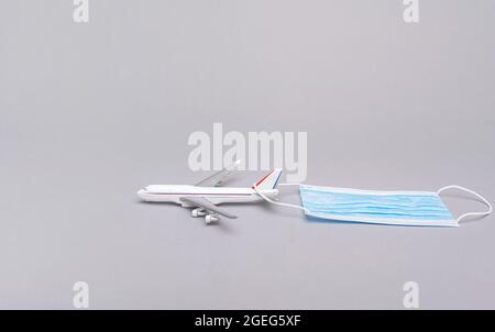 Airplane model and mask. COVID-19. Stock Photo