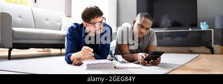 Happy Gay Couple Doing Taxes And Income Planning With Calculator Stock Photo