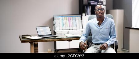 African Data Analyst Man Using Spreadsheet On Computer Stock Photo