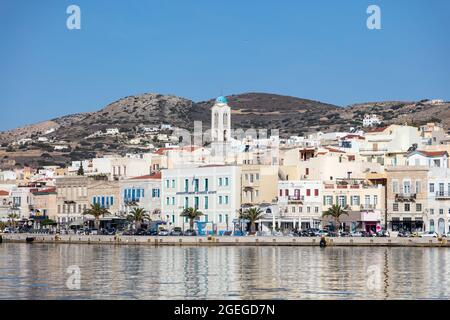 Syros island, Cyclades, Greece. May 27, 2021. Ermoupolis cityscape, waterfront buildings on the coastline, view from the sea. Sunny summer day, blue s Stock Photo