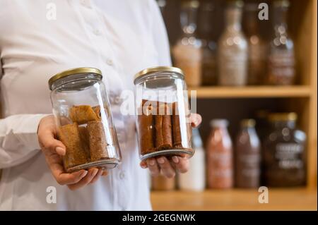 A woman holds a jar with Sweet pureed fruit pastila. Natural weight sweets in an eco store Stock Photo