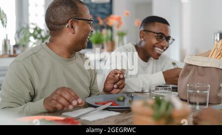 Happy Hispanic family having fun eating healthy lunch together at home Stock Photo