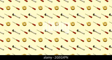 Screwdrivers, adjustable keys and electrical tape on a yellow background, pattern, hard shadows. Construction tools, repairs. Background for the desig Stock Photo