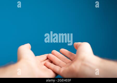 Male shows outstretched hand with open palm Stock Photo