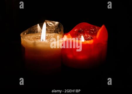 light candle burning brightly in the black background. Candle flame. Stock Photo