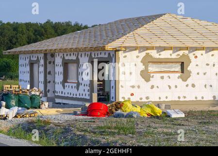 plastering work on the foam-insulated facade of a new private house. Construction and architectureof houses. Stock Photo