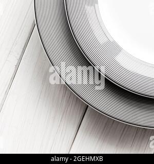 The modern classical porcelain set of plates stands on a white table Stock Photo