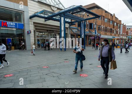 London, UK.  20 August 2021.  People shopping in front of St Ann's shopping centre in Harrow-on-the-Hill, north-west London.  The Office for National Statistics (ONS) has announced that UK retail sales dropped in July to their lowest level since shops reopened in April with retailers reporting that Euro 2020 football tournament and bad weather kept shoppers away from stores.  Credit: Stephen Chung / Alamy Live News Stock Photo