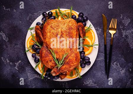Fried chicken with rosemary and garnish served on a white plate, top view. Stock Photo