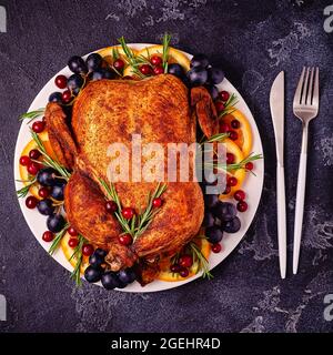 Fried chicken with rosemary and garnish served on a white plate, top view. Stock Photo