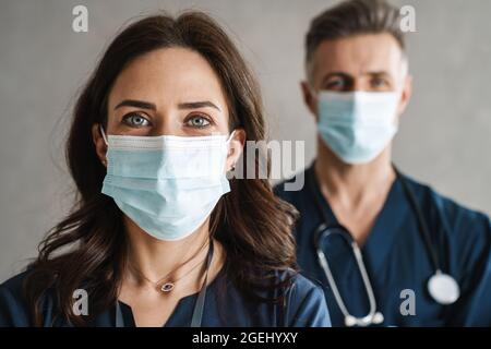 Two confident doctors in medical masks standing indoors Stock Photo
