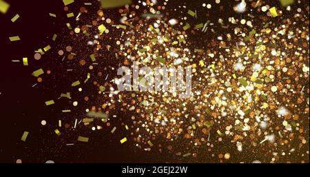 Image of gold confetti falling over glowing golden spots in the background Stock Photo