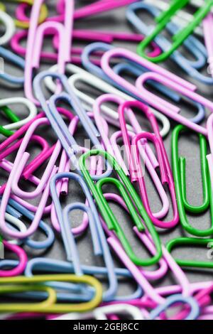 Multicolored paper clips scattered as textured background in full screen Stock Photo
