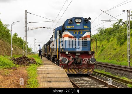 02413 Madgaon - New Delhi Rajdhani Special waiting for crossing at Vaibhavwadi Road Railway Station on Konkan Railway in Maharashtra, India. Stock Photo