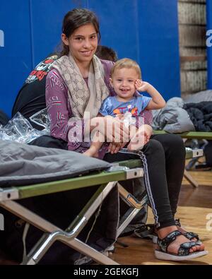 Al Udeied Air Base, Qatar. 20th Aug, 2021. Evacuees from Kabul wait at a shelter after arriving for processing August 20, 2021 at Al Udeied Air Base, Qatar. Credit: Planetpix/Alamy Live News Stock Photo