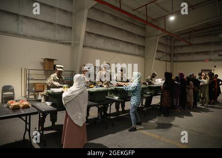 Al Udeied Air Base, Qatar. 17th Aug, 2021. U.S. Army soldiers serve a meal to Afghan Special Immigrants evacuated from Kabul at a dining facility set up to process non-combatants August 17, 2021 at Al Udeied Air Base, Qatar. Credit: Planetpix/Alamy Live News Stock Photo