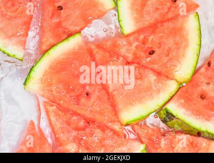Slices of melon in water on white background. Melon close-up in liquid with bubbles. Slices of red ripe melon in water. Macro image of fruits in water Stock Photo