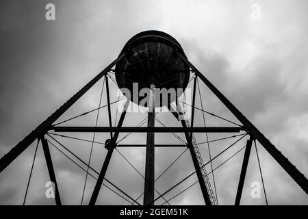 Old water tower and stormy sky in monochropme at Camp North End in Charlotte, North Carolina, USA. SIlhouette Stock Photo