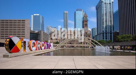 Toronto, Canada, August 10, 2021: Famous Toronto City Hall and Nathan Phillips Square fountain, a major tourist attraction and social hub for public events and festivals Stock Photo