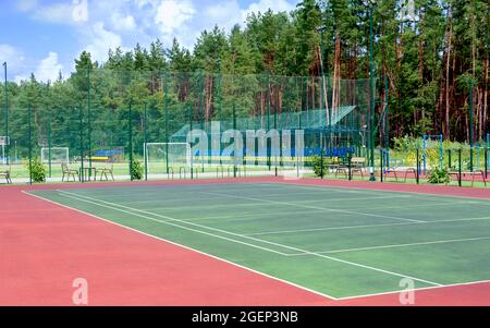 Sports ground on the outskirts of the city in a wooded area. View of the tennis court, fitness equipment, football field and others public sports grou Stock Photo